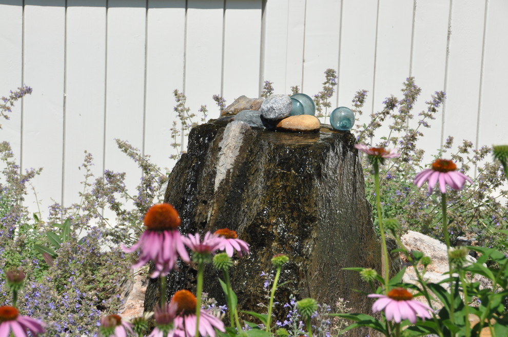 Imagen de jardín contemporáneo pequeño en patio trasero con fuente, exposición total al sol y adoquines de piedra natural
