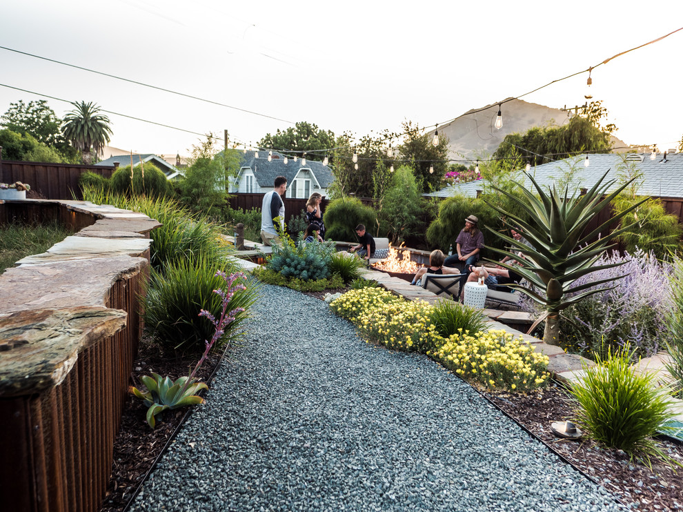 Photo of a mid-sized mediterranean drought-tolerant backyard retaining wall landscape in San Luis Obispo.