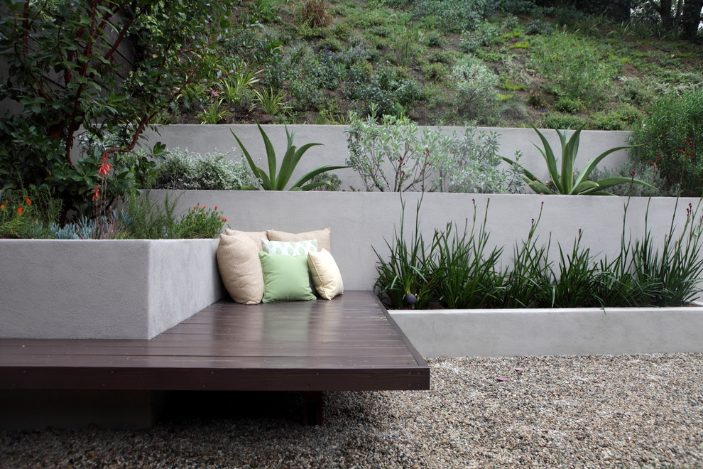 Immagine di un giardino minimalista dietro casa con un muro di contenimento e ghiaia