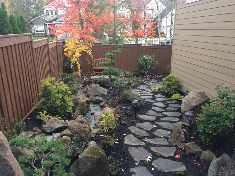 Kleiner Asiatischer Garten hinter dem Haus mit Wasserspiel und Natursteinplatten in Portland