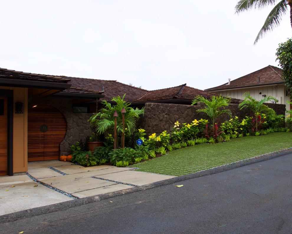 This is an example of a large world-inspired front formal partial sun garden in Hawaii with mulch.