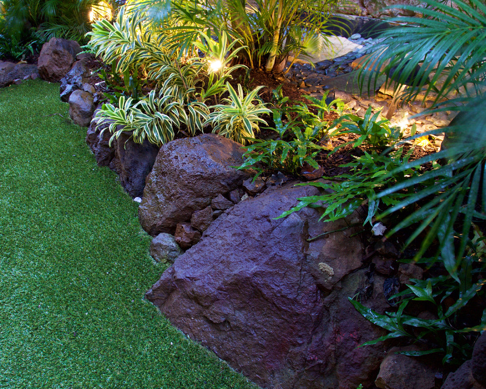 Idee per un grande giardino formale tropicale esposto a mezz'ombra davanti casa con pacciame