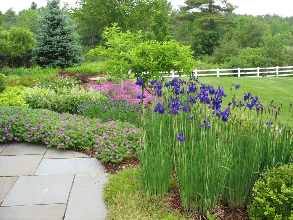 Geometrischer Klassischer Garten hinter dem Haus mit direkter Sonneneinstrahlung, Betonboden und Blumenbeet in Burlington