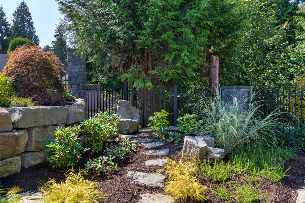 Inspiration for an expansive victorian front formal full sun garden for spring in Vancouver with a fire feature and natural stone paving.
