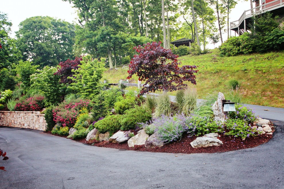 Photo of a mid-sized traditional full sun hillside stone retaining wall landscape in Charlotte for summer.
