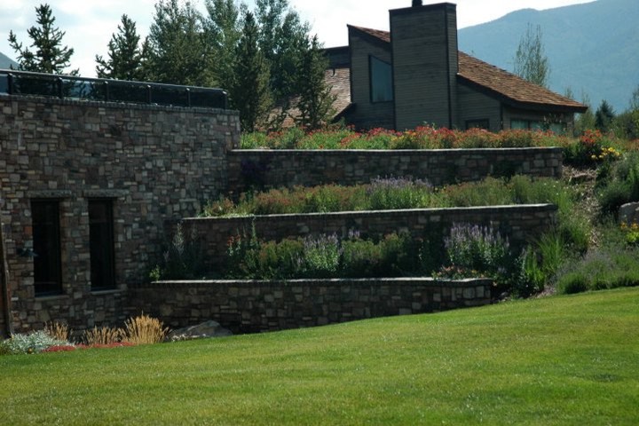Photo of a large traditional sloped garden in Denver with a retaining wall.