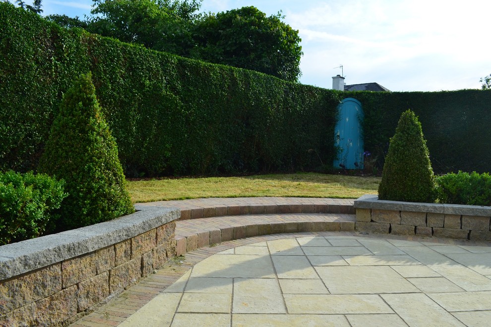 This is an example of a small traditional back formal full sun garden for summer in Other with a garden path and concrete paving.