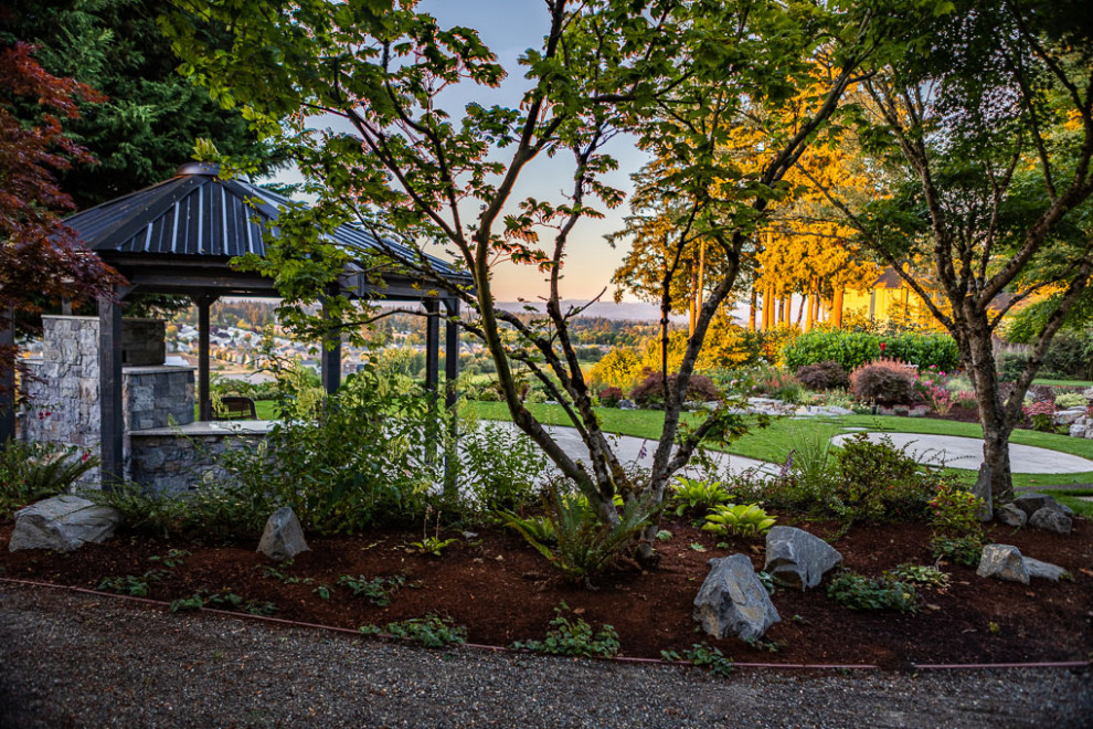 Immagine di un grande giardino contemporaneo esposto a mezz'ombra dietro casa con un caminetto e pavimentazioni in pietra naturale
