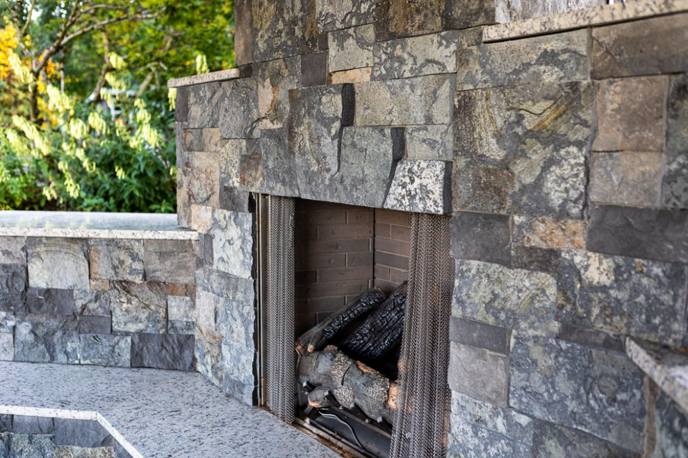 ポートランドにあるラグジュアリーな広いコンテンポラリースタイルのおしゃれな裏庭 (屋外暖炉、半日向、天然石敷き) の写真
