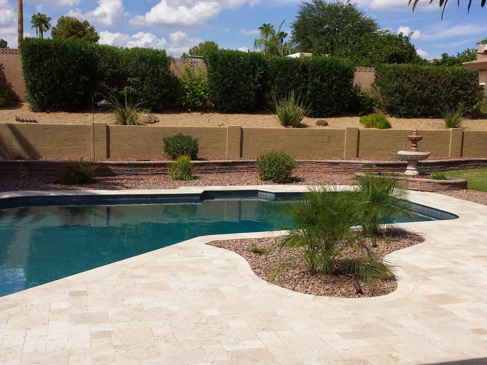 Inspiration for a mid-sized modern full sun backyard stone landscaping in Phoenix.