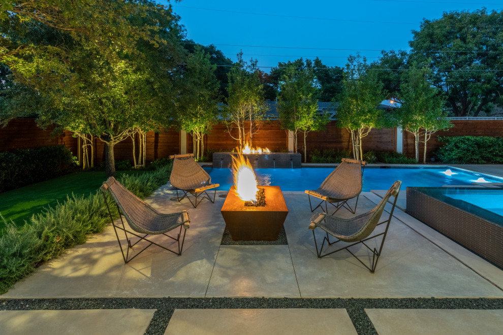 Photo of a large contemporary backyard water fountain landscape in Dallas.