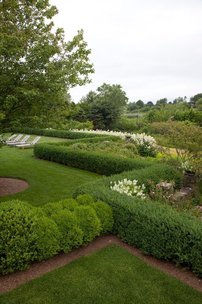 На фото: регулярный сад на заднем дворе в классическом стиле с