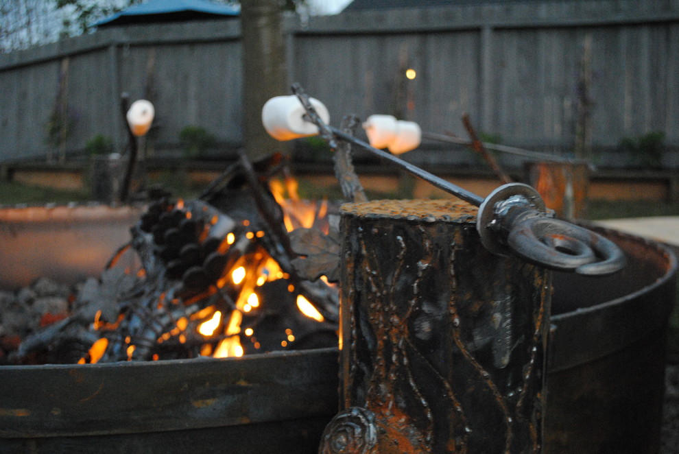 Inspiration for a large rustic partial sun backyard concrete paver landscaping in Sacramento with a fire pit.