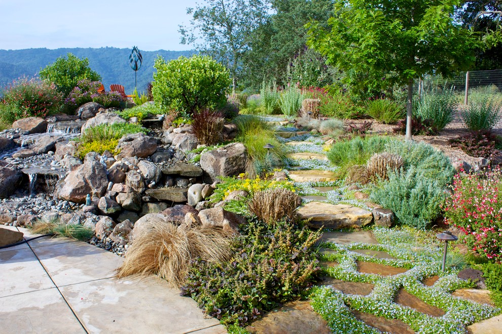 Ispirazione per un giardino classico esposto in pieno sole con fontane, passi giapponesi e pavimentazioni in pietra naturale