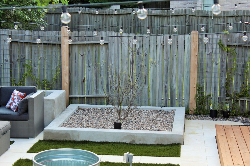 Ejemplo de jardín moderno de tamaño medio en patio trasero con brasero y adoquines de hormigón