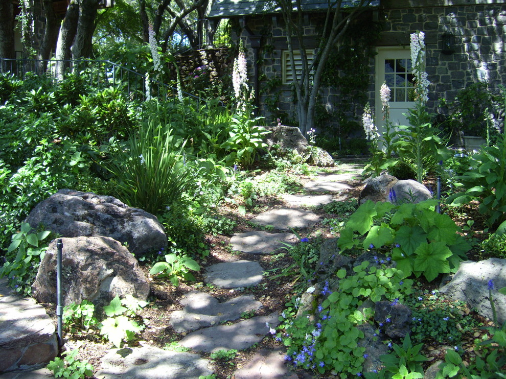 Idéer för att renovera en stor rustik trädgård i skuggan framför huset, med en trädgårdsgång och naturstensplattor