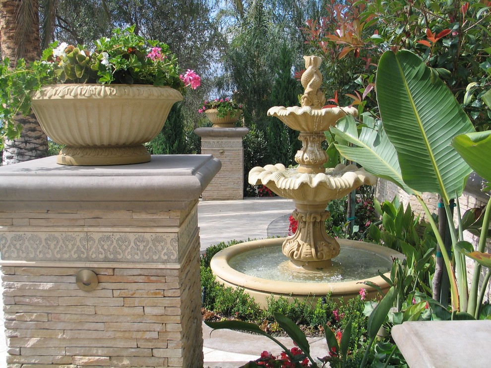 Inspiration för en medelhavsstil trädgård, med en fontän