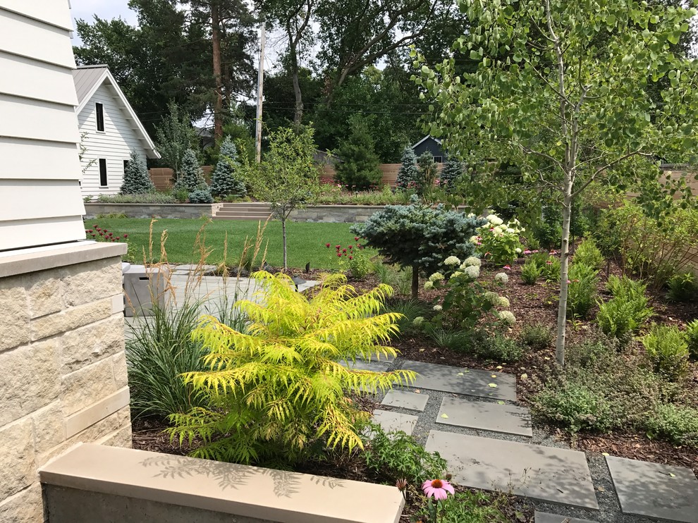 На фото: солнечный, летний регулярный сад среднего размера на заднем дворе в стиле модернизм с садовой дорожкой или калиткой, хорошей освещенностью и покрытием из каменной брусчатки с