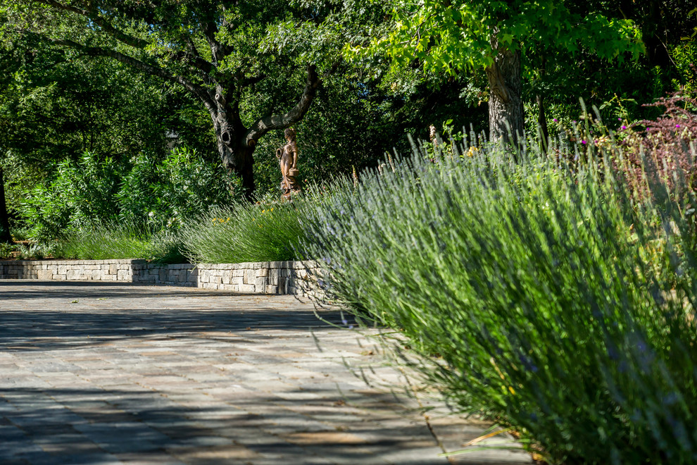 Пример оригинального дизайна: большой участок и сад на боковом дворе в стиле неоклассика (современная классика) с подъездной дорогой, полуденной тенью и покрытием из каменной брусчатки