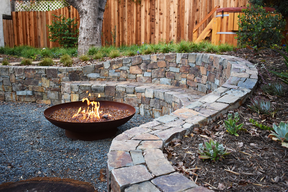 Design ideas for a mid-sized transitional partial sun backyard gravel landscaping in Los Angeles with a fire pit.