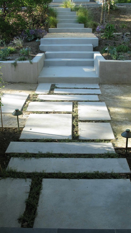 Inspiration för en stor funkis formell trädgård i delvis sol framför huset på våren, med en trädgårdsgång och marksten i betong