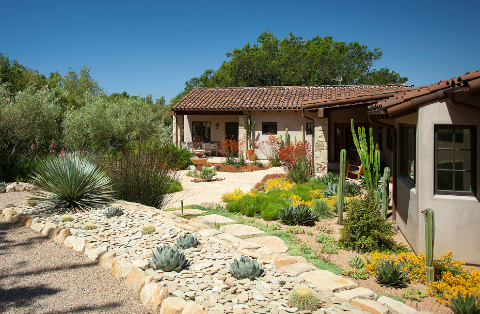 На фото: участок и сад на переднем дворе в средиземноморском стиле с пустынными растениями с