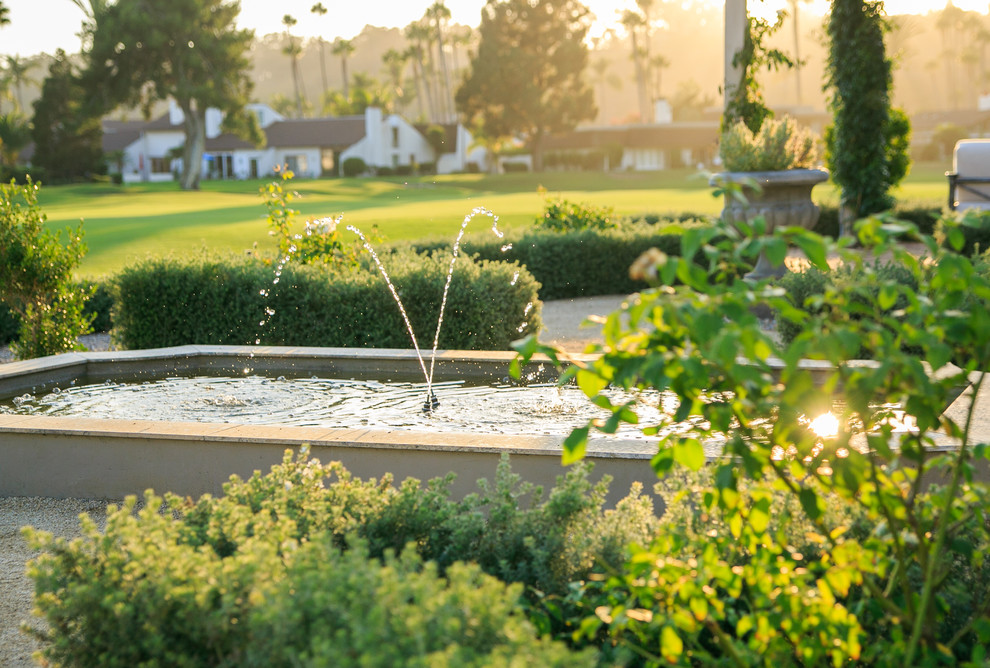 Ejemplo de jardín mediterráneo de tamaño medio en patio trasero con jardín francés, exposición total al sol, adoquines de ladrillo, estanque y con metal
