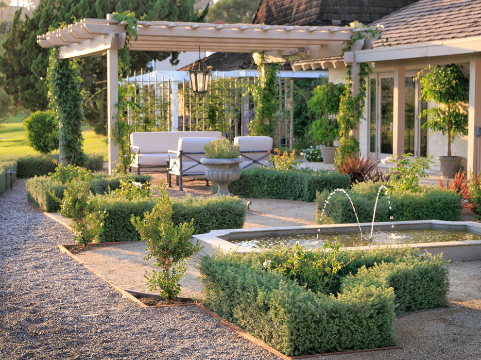 Foto di un giardino formale mediterraneo esposto in pieno sole di medie dimensioni e dietro casa con pavimentazioni in mattoni, un ingresso o sentiero e recinzione in metallo