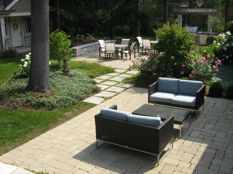Exempel på en stor modern bakgård i delvis sol, med en trädgårdsgång och naturstensplattor