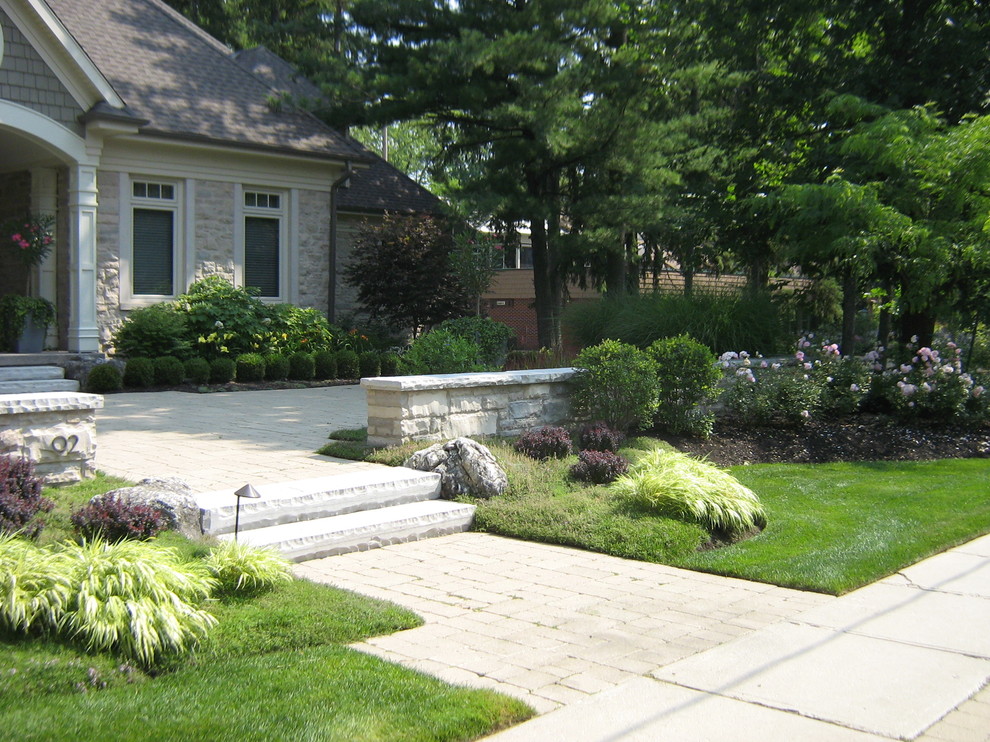 Imagen de jardín moderno grande en patio con muro de contención y adoquines de hormigón