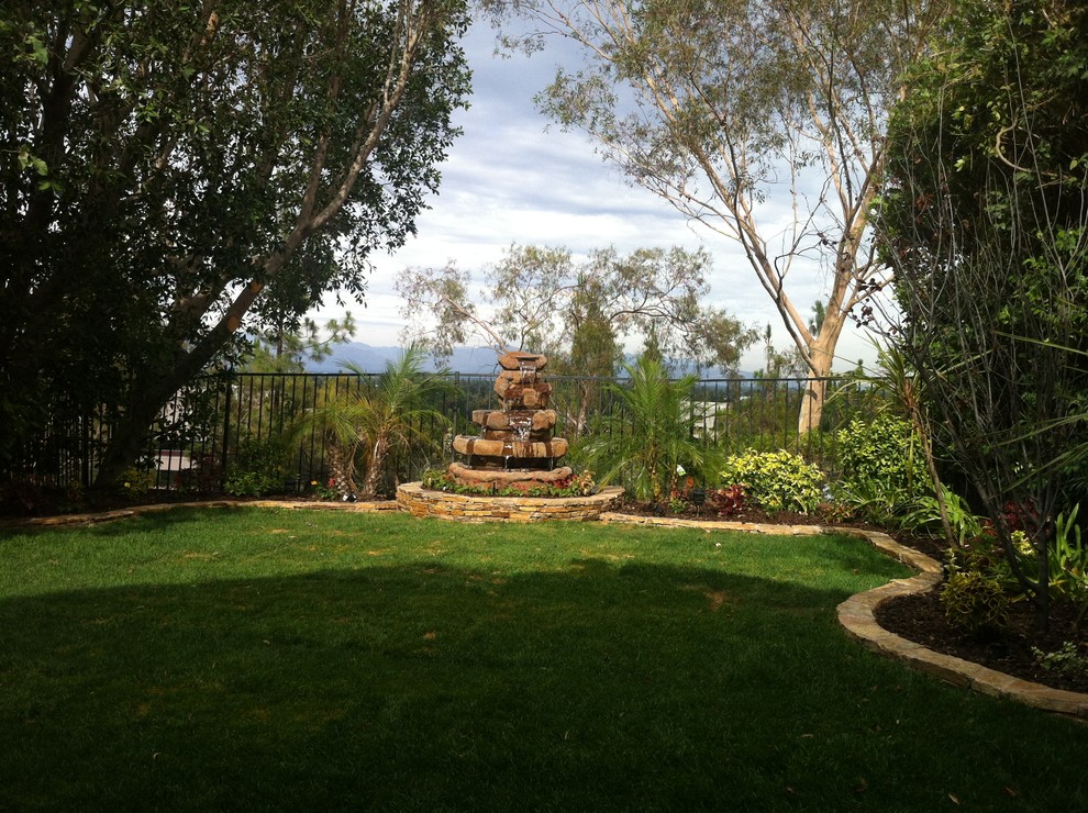 Medium sized classic back partial sun garden in Los Angeles with natural stone paving.
