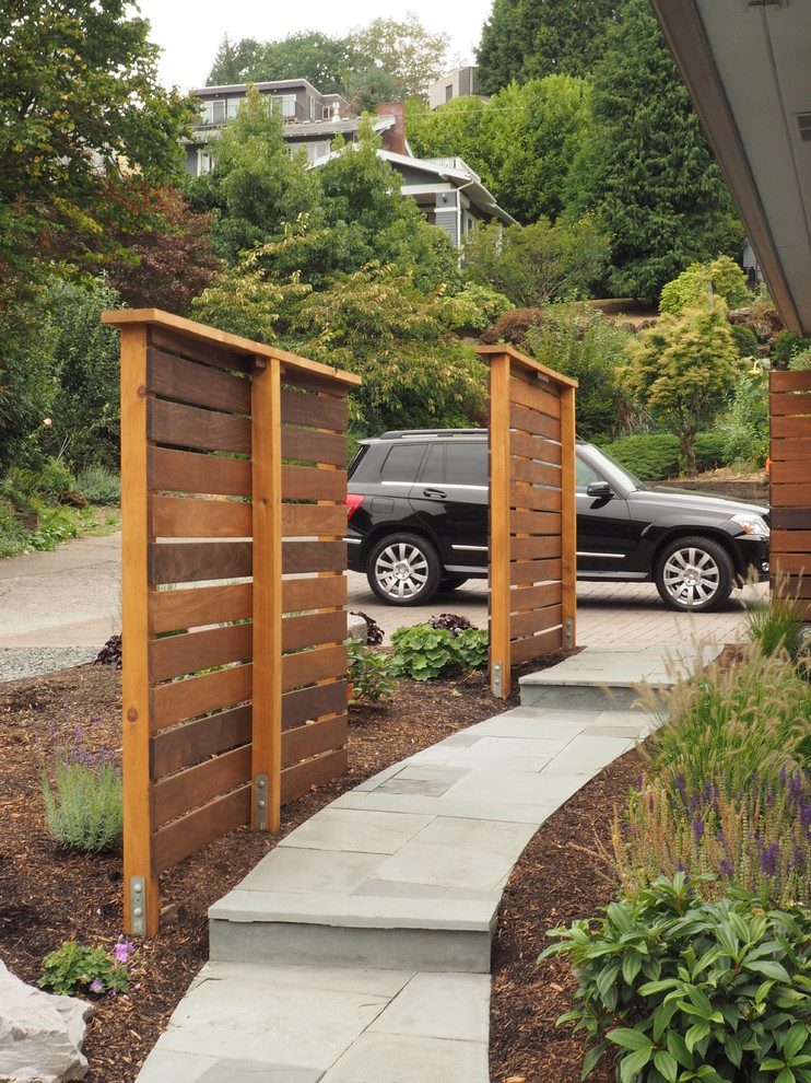 This is an example of a large modern front driveway full sun garden in Portland with concrete paving.