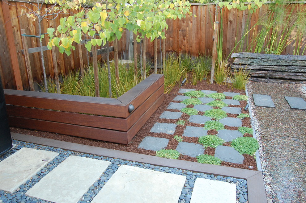 Ejemplo de jardín contemporáneo pequeño en patio trasero con exposición parcial al sol y adoquines de piedra natural