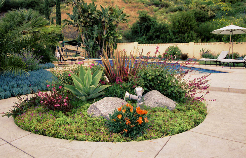 This is an example of a large mediterranean full sun backyard concrete paver landscaping in Los Angeles.