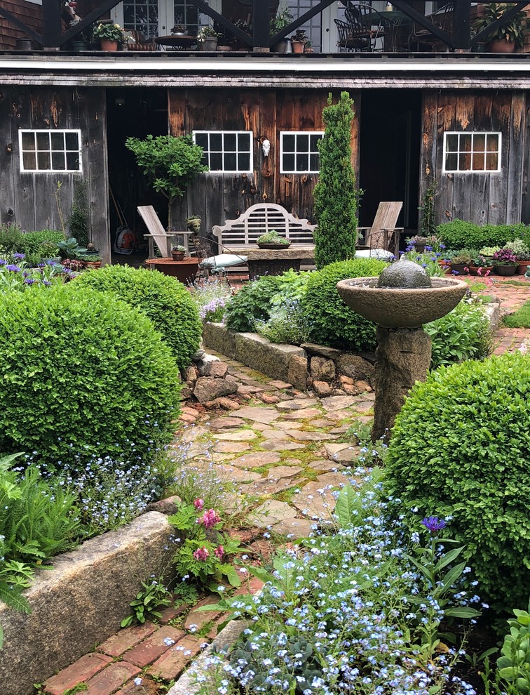 Design ideas for a farmhouse full sun backyard brick garden path in Boston.
