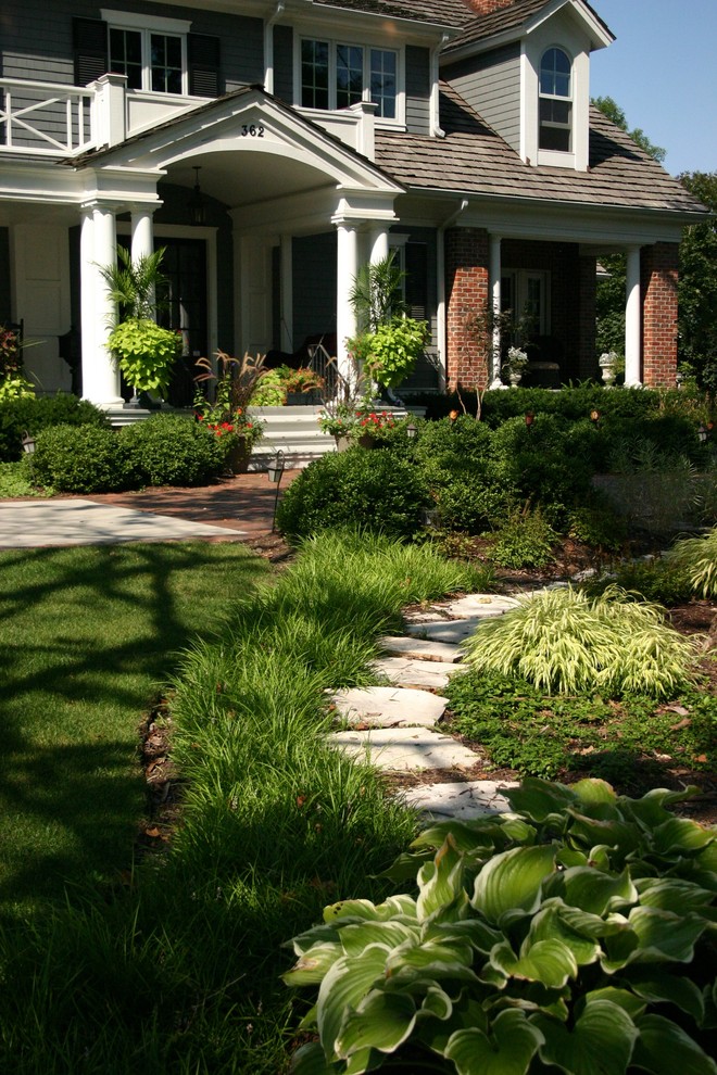 Foto di un grande giardino formale tradizionale esposto a mezz'ombra davanti casa in estate con pavimentazioni in pietra naturale e un ingresso o sentiero