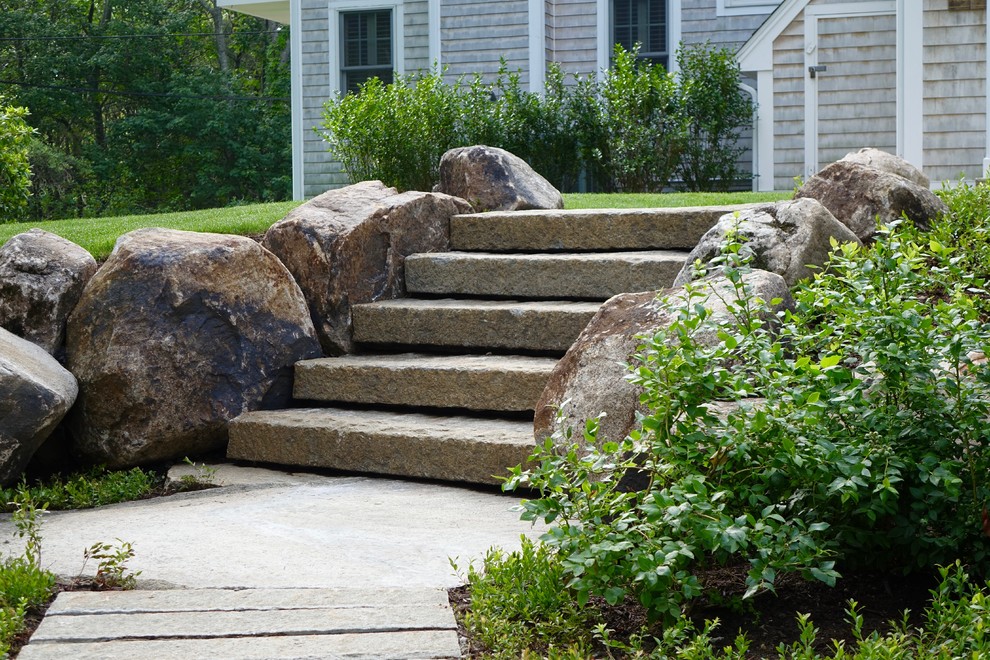 This is an example of a rustic hillside stone retaining wall landscape in Portland Maine.