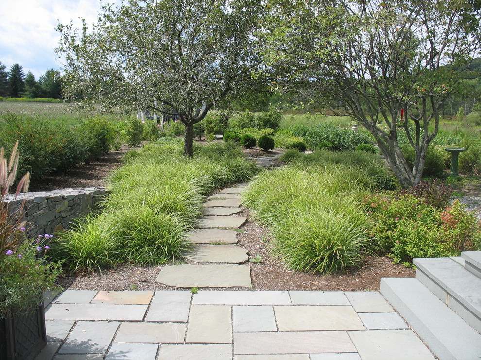 Contemporary back formal partial sun garden for summer in Burlington with natural stone paving and a garden path.