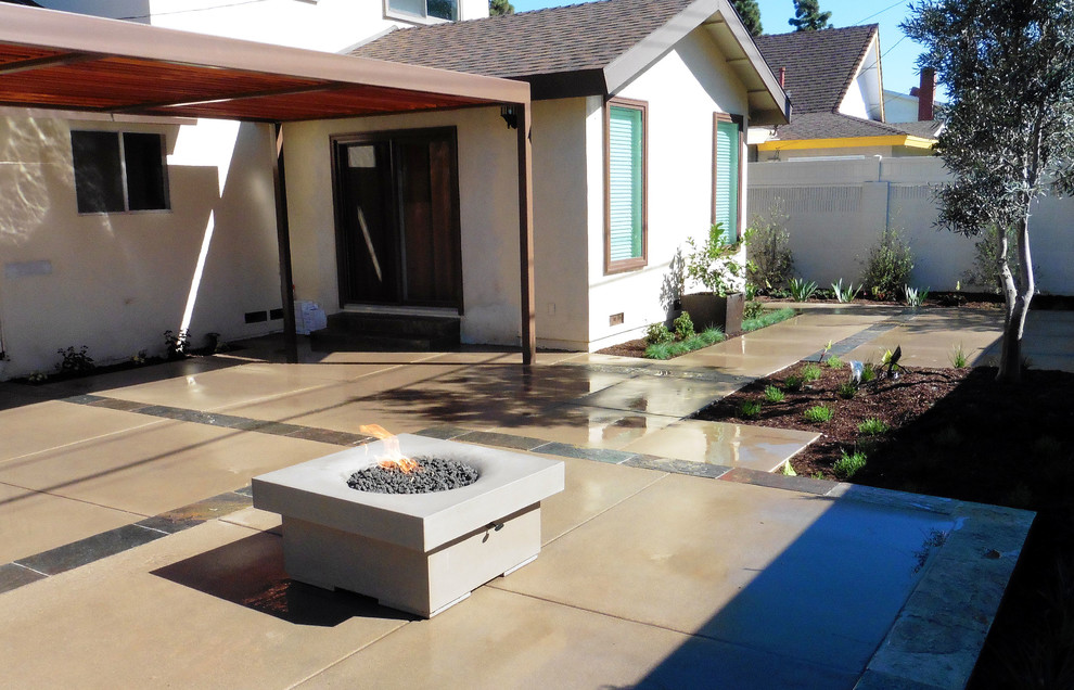 Medium sized modern back full sun garden for summer in Orange County with a fire feature and natural stone paving.