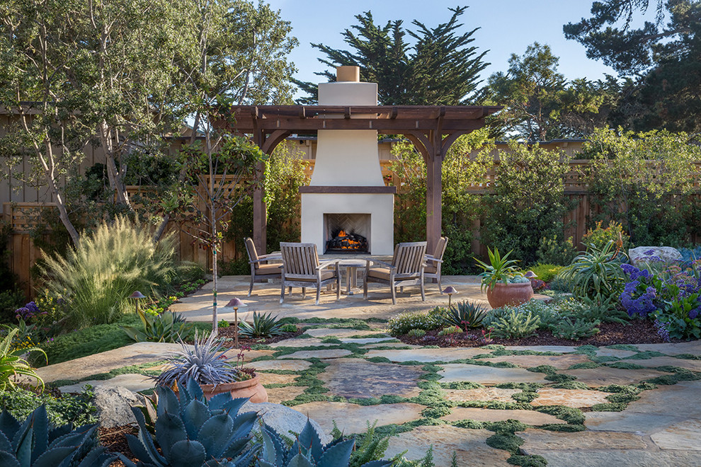 Inspiration for a mediterranean backyard stone and wood fence landscaping in Other with a pergola.
