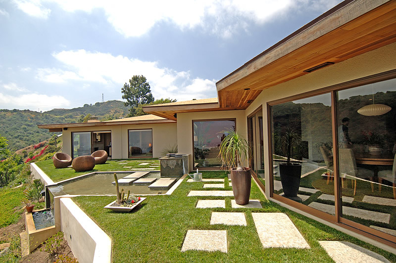 Cette image montre un jardin arrière design de taille moyenne avec un point d'eau, des pavés en béton et une exposition ensoleillée.