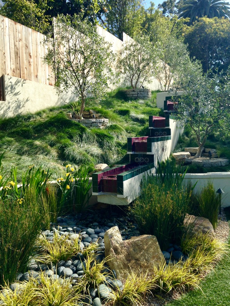 Modelo de jardín de secano mediterráneo de tamaño medio en patio trasero con estanque y exposición total al sol