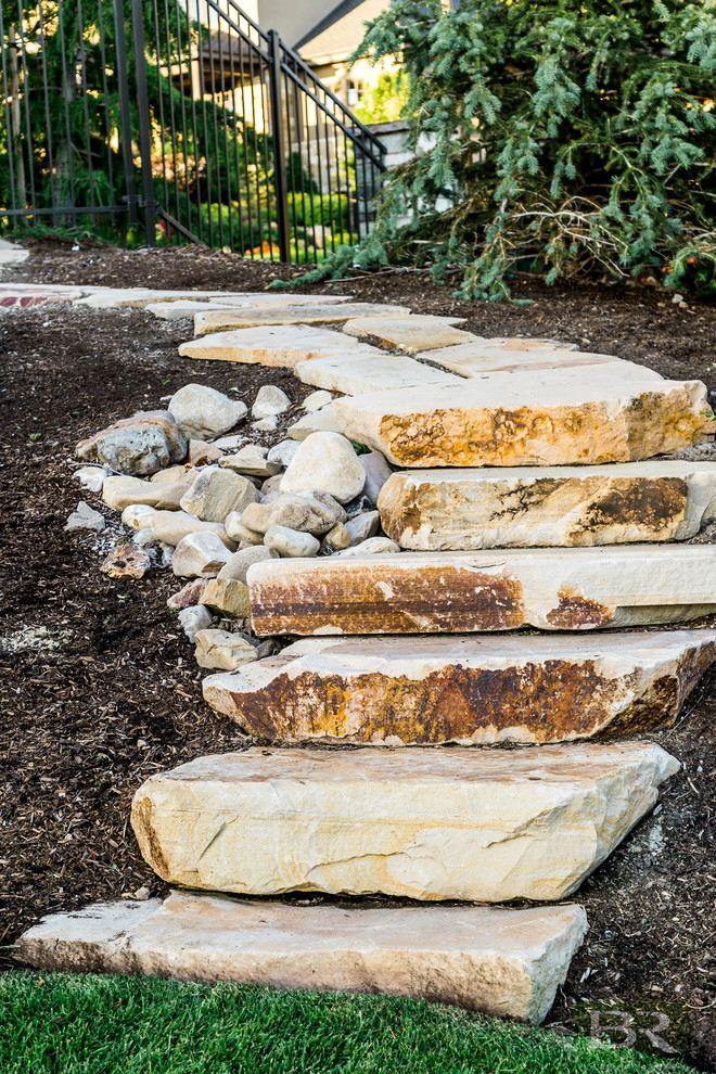 Foto de jardín clásico de tamaño medio en patio trasero con adoquines de piedra natural