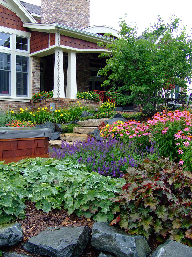 Exempel på en amerikansk trädgård framför huset och blomsterrabatt