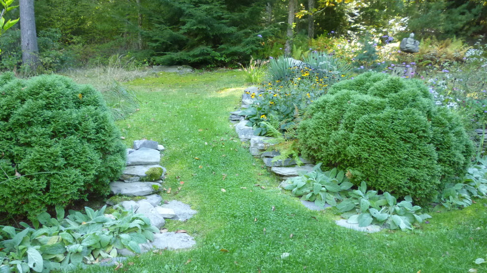 Ispirazione per un ampio giardino xeriscape rustico esposto a mezz'ombra in estate con un muro di contenimento, un pendio, una collina o una riva e pavimentazioni in pietra naturale
