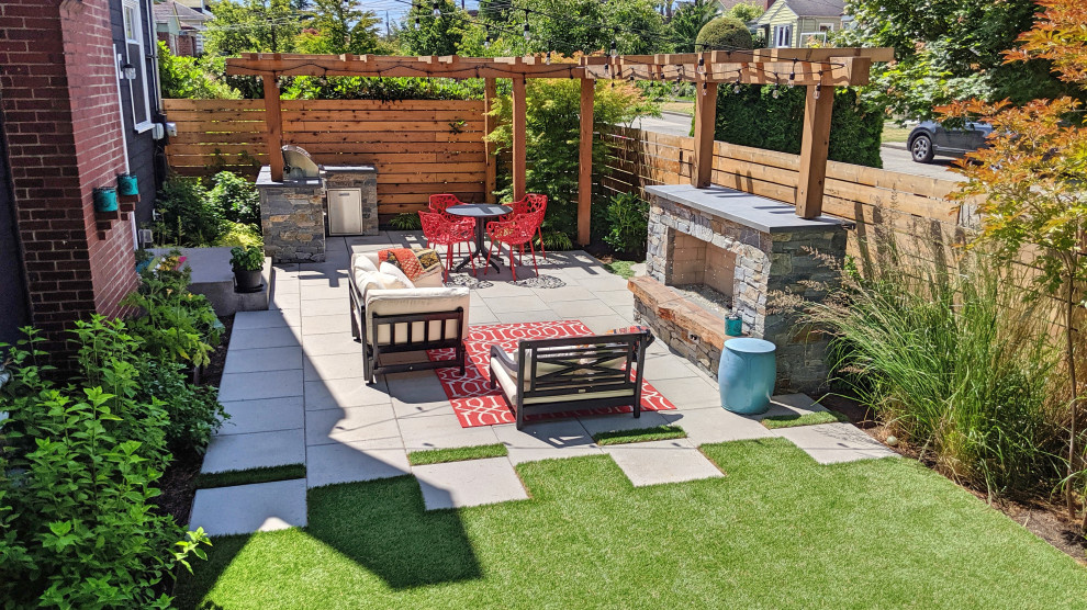 シアトルにある中くらいなおしゃれな横庭 (ゼリスケープ、屋外暖炉、日向、コンクリート敷き	) の写真