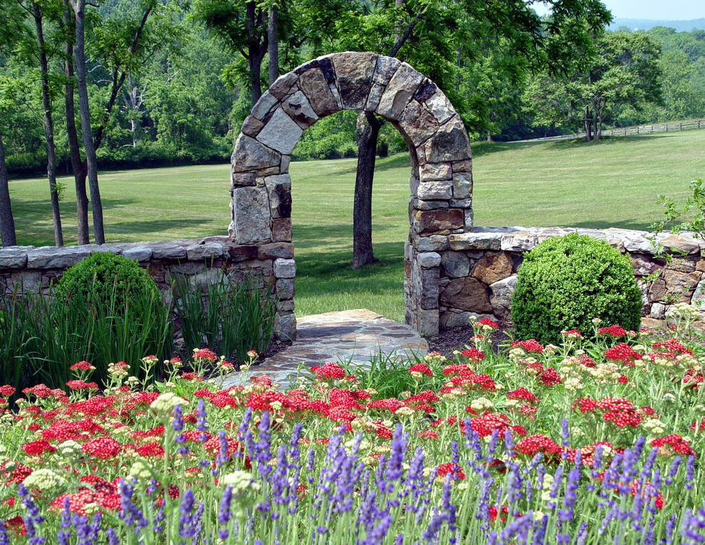 Exemple d'un très grand jardin arrière chic l'été avec des pavés en pierre naturelle et une exposition ensoleillée.