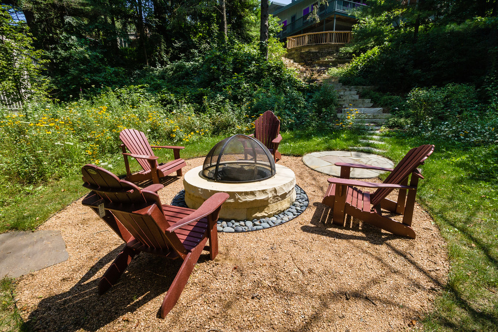 This is an example of a mid-sized modern partial sun backyard gravel landscaping in Milwaukee with a fire pit for summer.