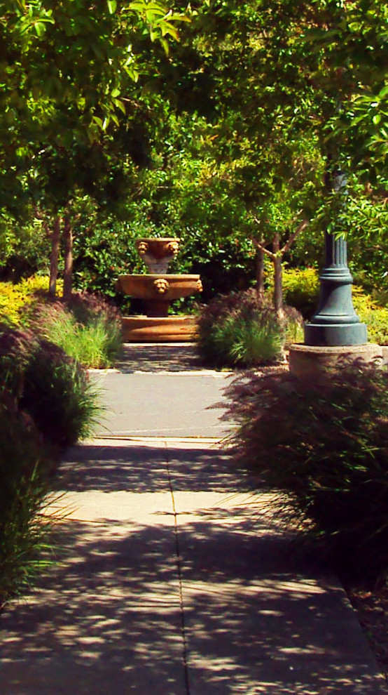 Idee per un ampio giardino formale minimalista esposto a mezz'ombra in cortile in primavera con fontane, pavimentazioni in cemento e recinzione in legno