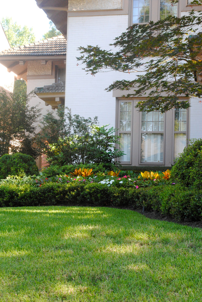 Esempio di un giardino formale tradizionale esposto a mezz'ombra di medie dimensioni e nel cortile laterale in primavera